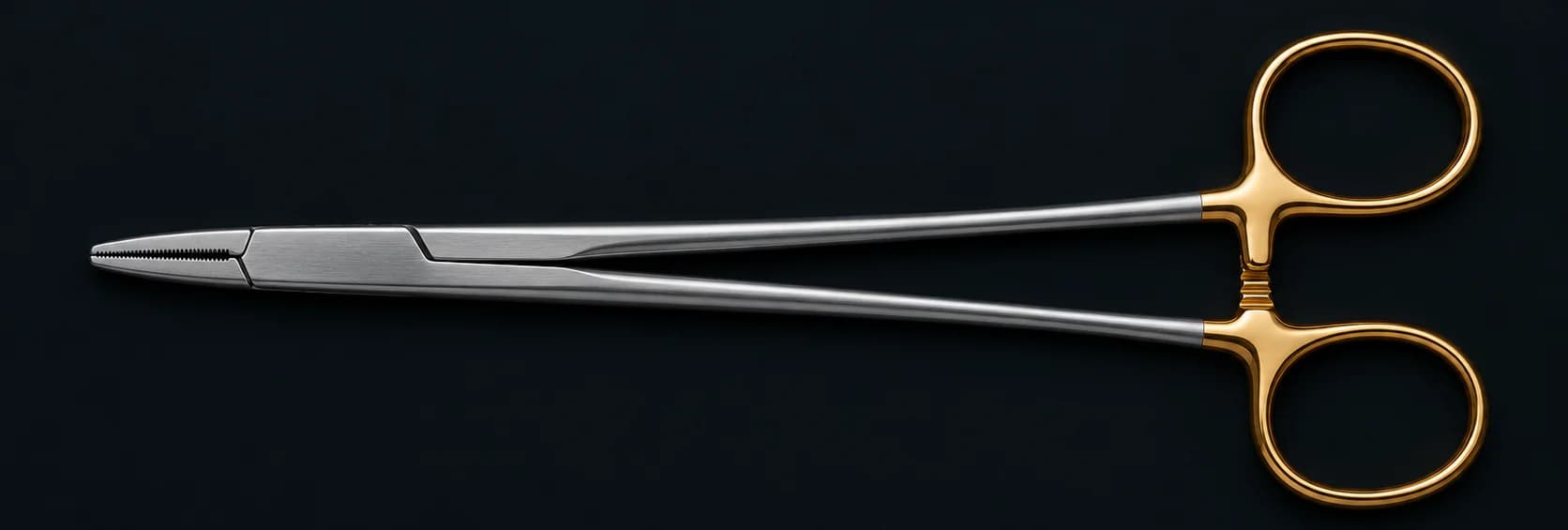 A Mayo-Hegar needle holder with gold carbide rings on a dark surface